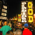 "Fear God" and "You Still Need Jesus" signs in the Bourbon Street crowd in New Orleans, LA