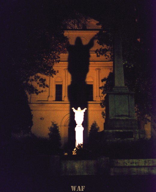 a spotlight highlighting a Jesus statue in the back courtyard of St. Louis Cathedral in the French Quarter in New Orleans, LA