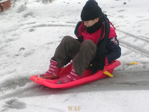 O meu filho brincado na neve