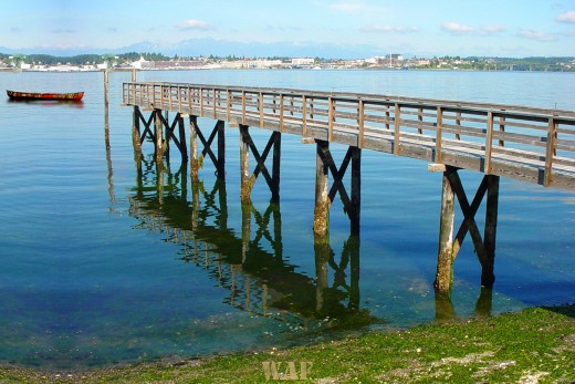 a Puget Sound pier and lonely boat on the water (Washington state)